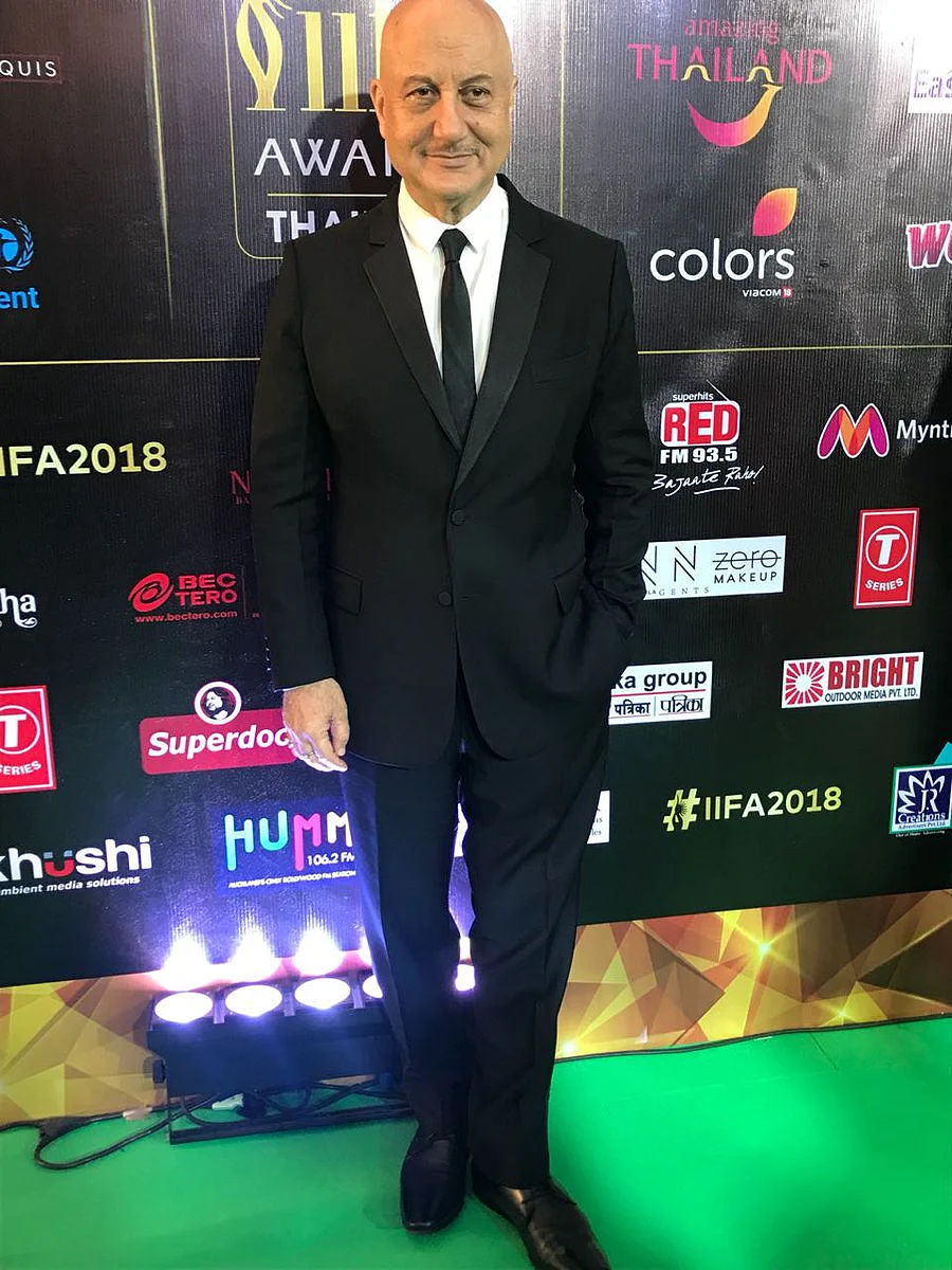 Anupam Kher keeps it simple in a black suit and a slim tie. 
