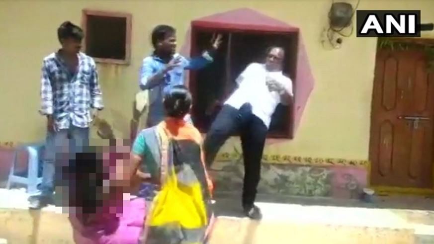 I Gopi, the president of Dharpally Mandal kicks a woman during a dispute.