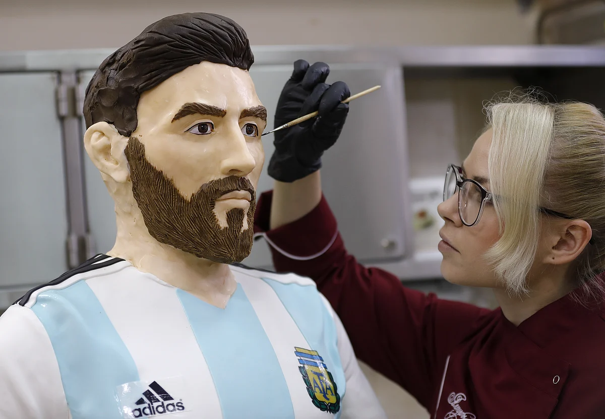 A confectioner giving final touches to the chocolate sculpture.
