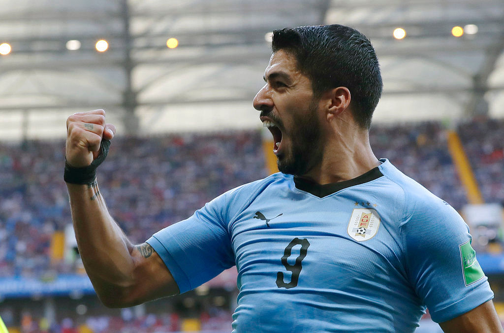 Luis Suarez marked his 100th international cap by helping Uruguay reach the last 16 of the FIFA World Cup.