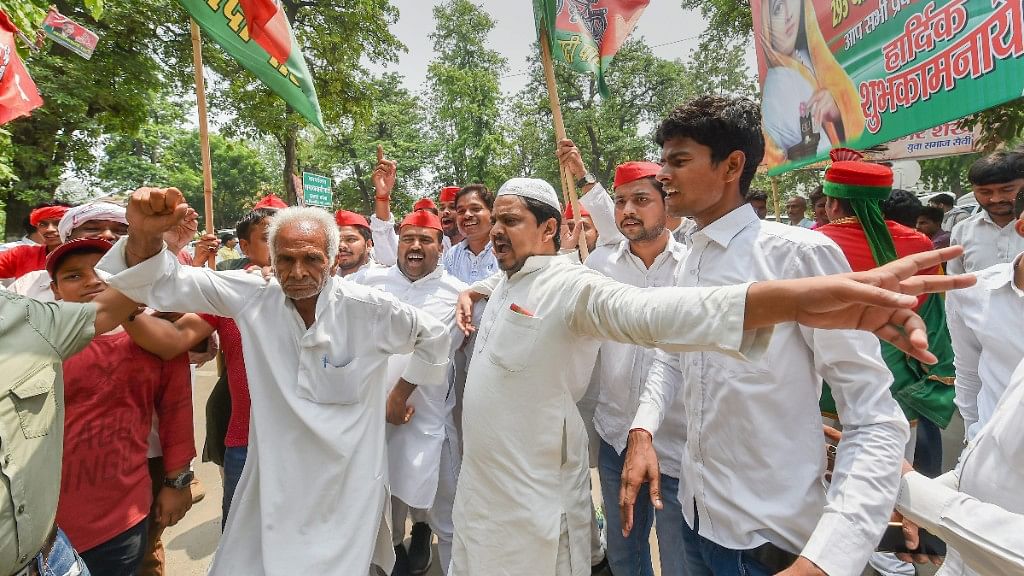 Samajwadi Party supporters celebrate after victory in Noorpur Assembly seat