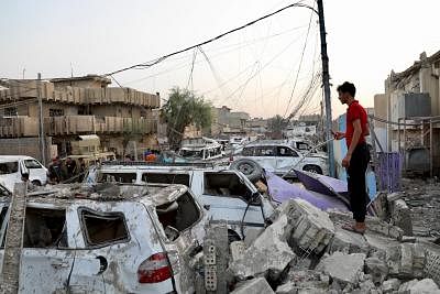BAGHDAD, June 7, 2018 (Xinhua) -- A man stands beside cars damaged at a huge explosion, in eastern Baghdad, Iraq, June 7, 2018. The death toll of a huge explosion in eastern Baghdad on Wednesday rose to 14, while more than 90 others were wounded, an Interior Ministry source said.  (Xinhua/Khalil Dawood/IANS)