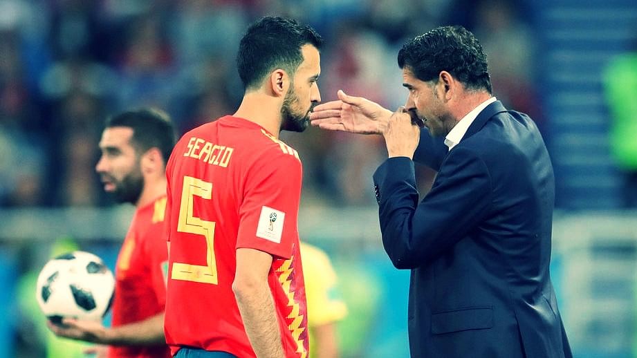 Spain head coach Fernando Hierro, right, speaks to Sergio Busquets during a World Cup match.