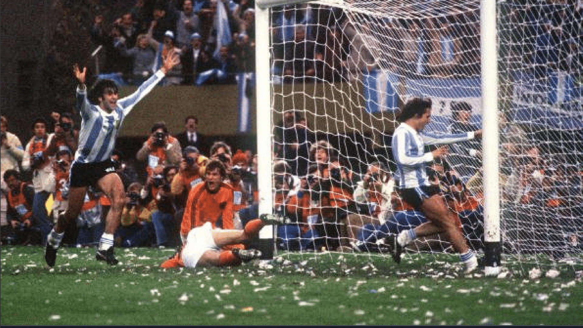 Mario Kempes (left) celebrates his second goal to secure the World Cup win amidst a ticker tape adulation by the crowd.