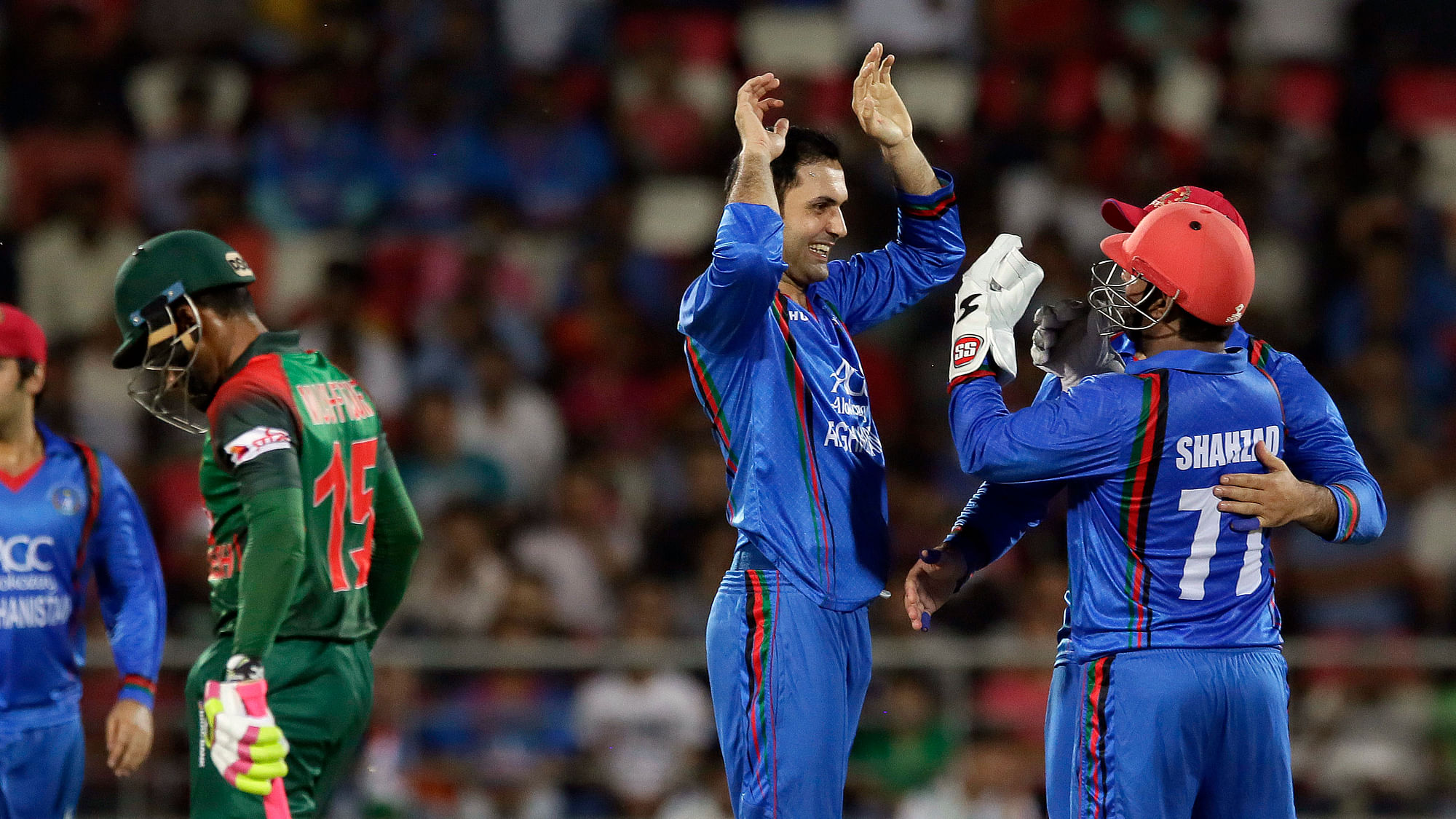 Afghanistan cricket players celebrate the wicket of Mushfiqur Rahim of Afghanistan during the second T20 cricket match between Afghanistan and Bangladesh in Dehraduni.