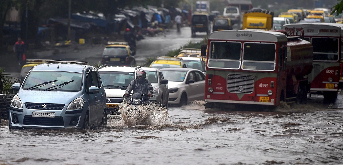Vehicles wade through water-logged tracks during heavy rains, in Mumbai on Monday, June 25, 2018. 