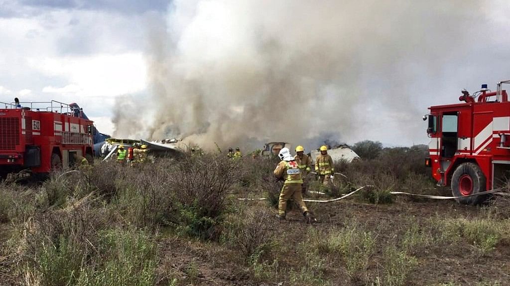 Rescue workers and firefighters seen at the site where an Aeromexico airliner suffered an “accident” in a field near the airport of Durango, Mexico, on 31 July.
