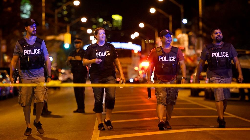 Plainclothes police officers work the scene of shooting in Toronto on Sunday, 22 July 2018.