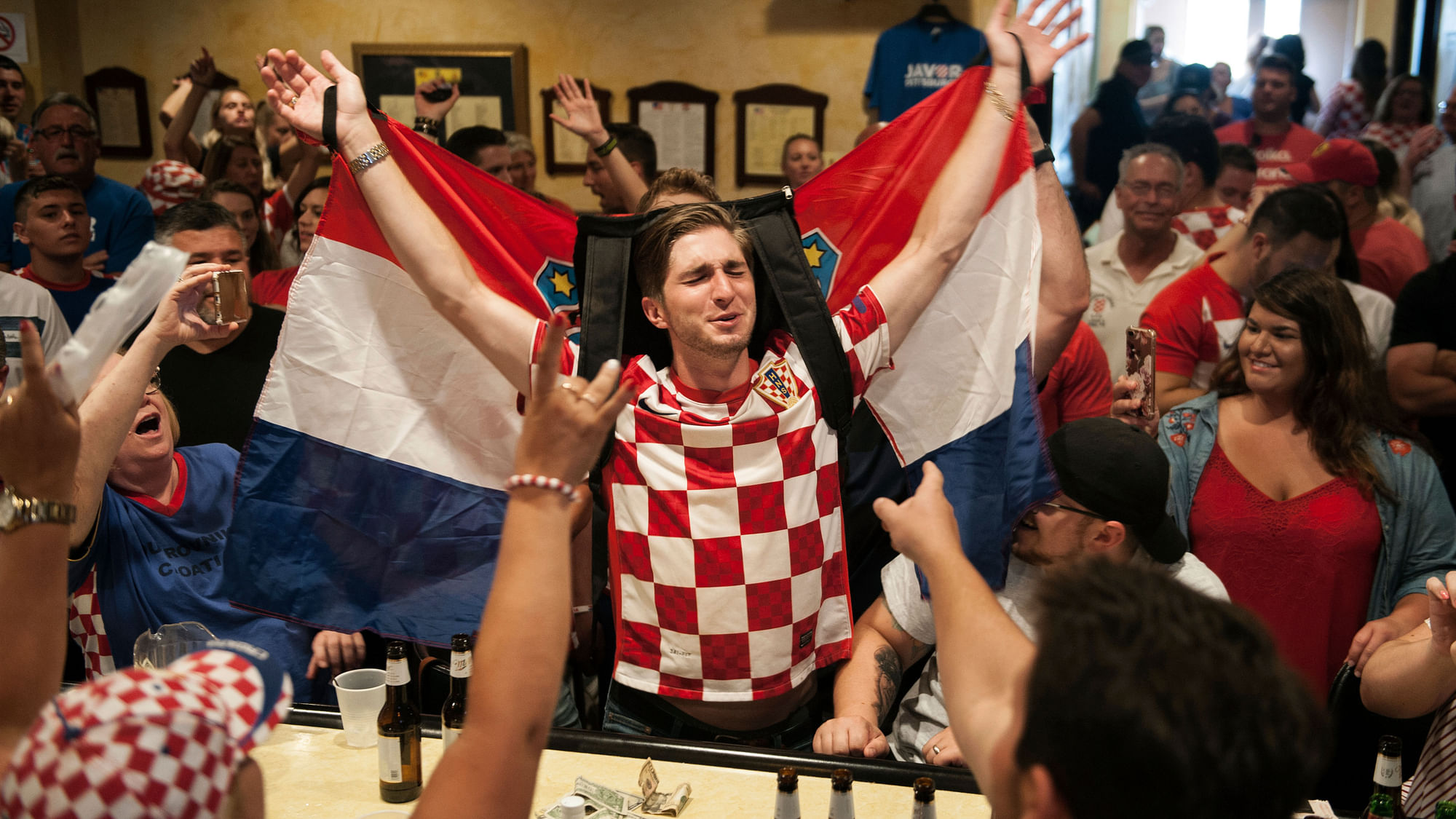 Marko Luketich Kochis, center, 26, of Cokeburg, raises the Croatian flag as he celebrates his team being in the World Cup final alongside other people of Croatian decent gathered to watch the game on Sunday, July 15, 2018.
