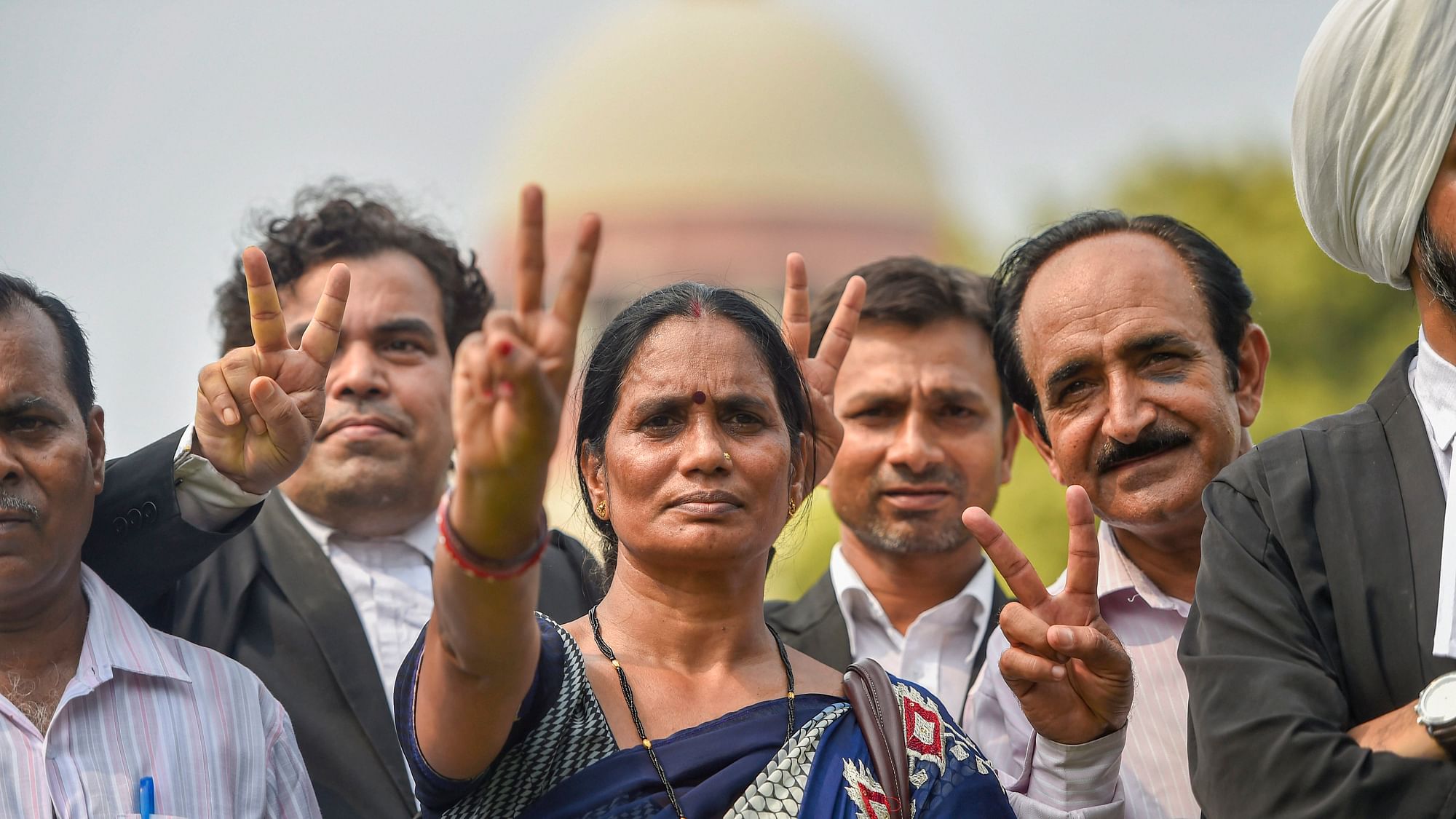 Nirbhayas parents show the victory sign after the Supreme Court verdict on the December 2012 gang rape case, in New Delhi on 9 July.