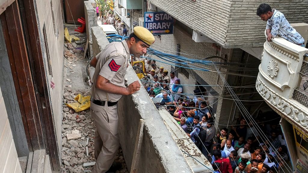  A policeman stands in the balcony of the house, where 11 members of a family were found dead  in Burari area of Delhi on 1 July.