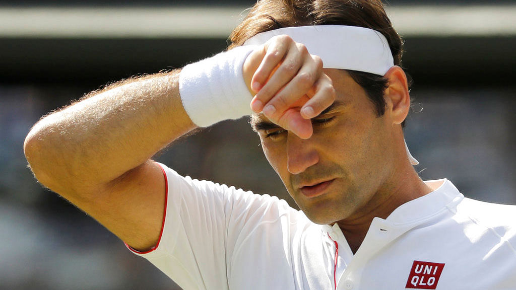  Roger Federer wipes his forehead during the fifth set of the Wimbledon quarter-final against Kevin Anderson.