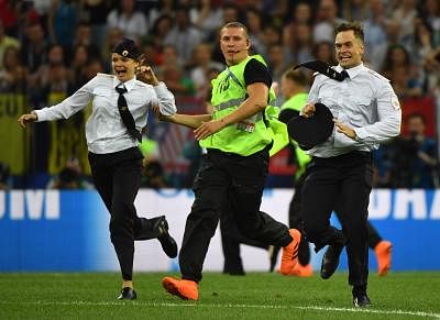 MOSCOW, July 15, 2018 (Xinhua) -- Pitch invaders are chased by stewards during the 2018 FIFA World Cup final match between France and Croatia in Moscow, Russia, July 15, 2018. (Xinhua/Li Ga/IANS)