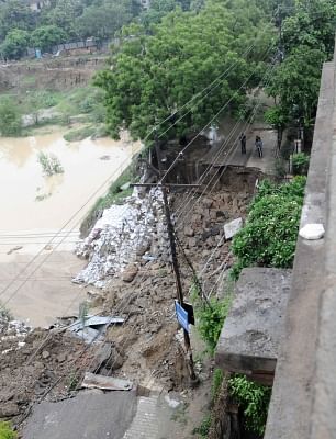 Vasundhara: A view of a damaged road at Vasundhara after a part of it caved in during heavy rains, in Ghaziabad on July 26, 2018. (Photo: IANS)