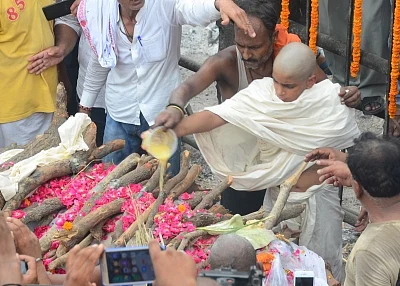 Varanasi: Sameer Singh, 14-year-old son of dreaded gangster Prem Prakash Singh alias Munna Bajrangi performs last rites of his father at Manikarnika Ghat in Varanasi on July 10, 2018. The 51-year-old Bajrangi was shot 10 times in the head and chest from close range with a sophisticated handgun and his body was dumped in a gutter inside the Baghpat jail on Monday morning, hours before he was to be produced in a court. (Photo: IANS)