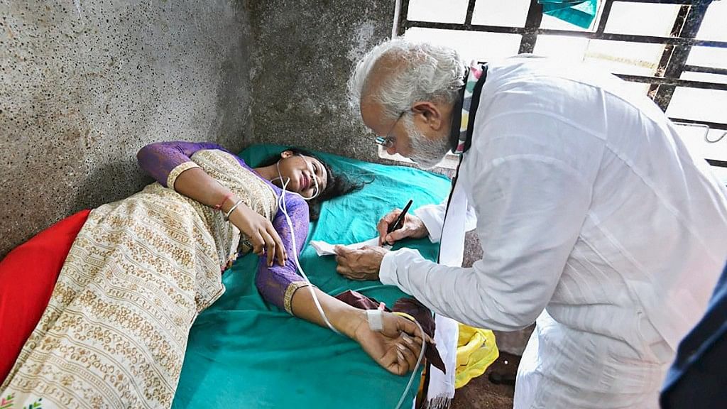 PM Modi signs an autograph for a woman who was injured during his rally in Midnapore.