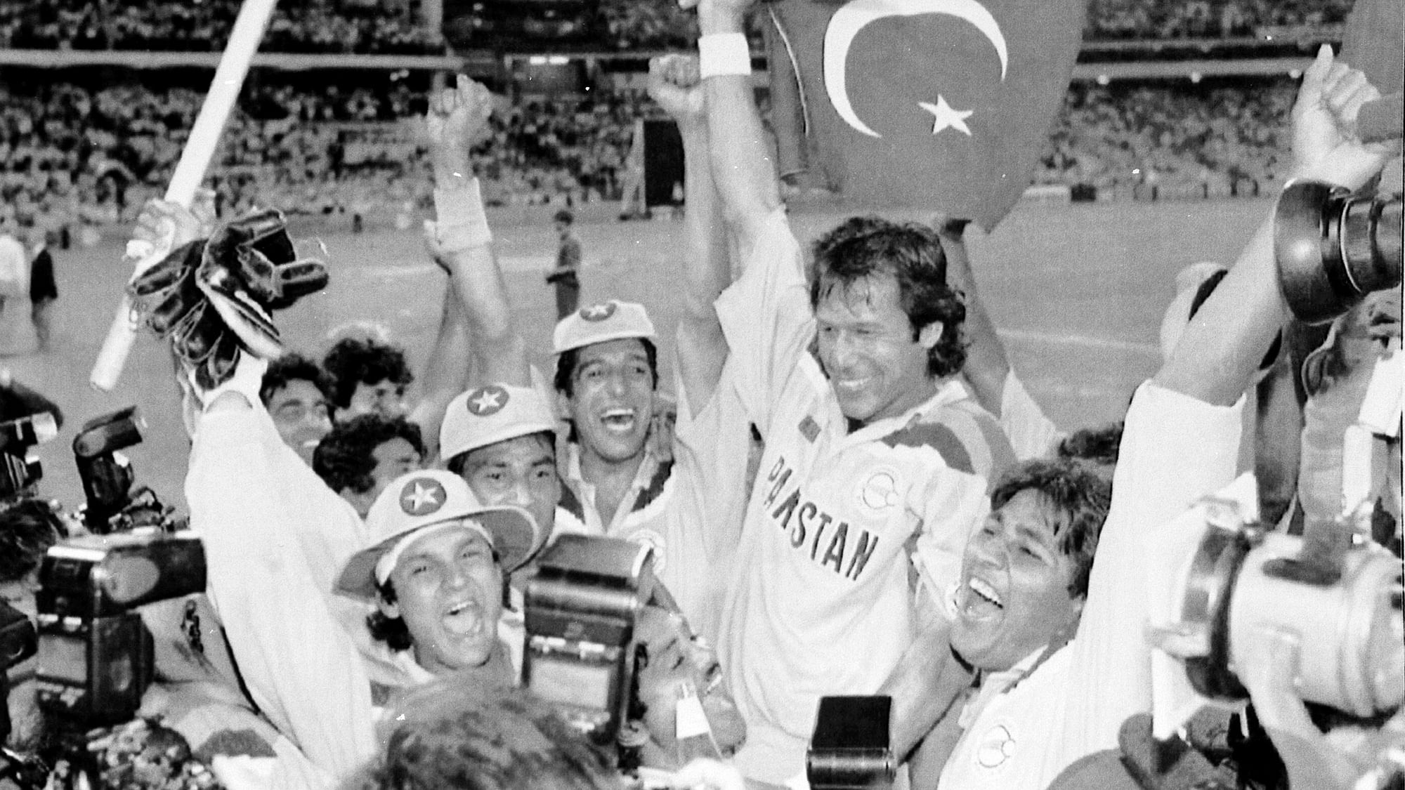 In this March 25, 1992 file photo, Pakistan’s cricket captain Imran Khan, waving a Pakistan flag, is cheered by his teammates after Pakistan defeated England in the World Cup Cricket final, in Melbourne, Australia.&nbsp;
