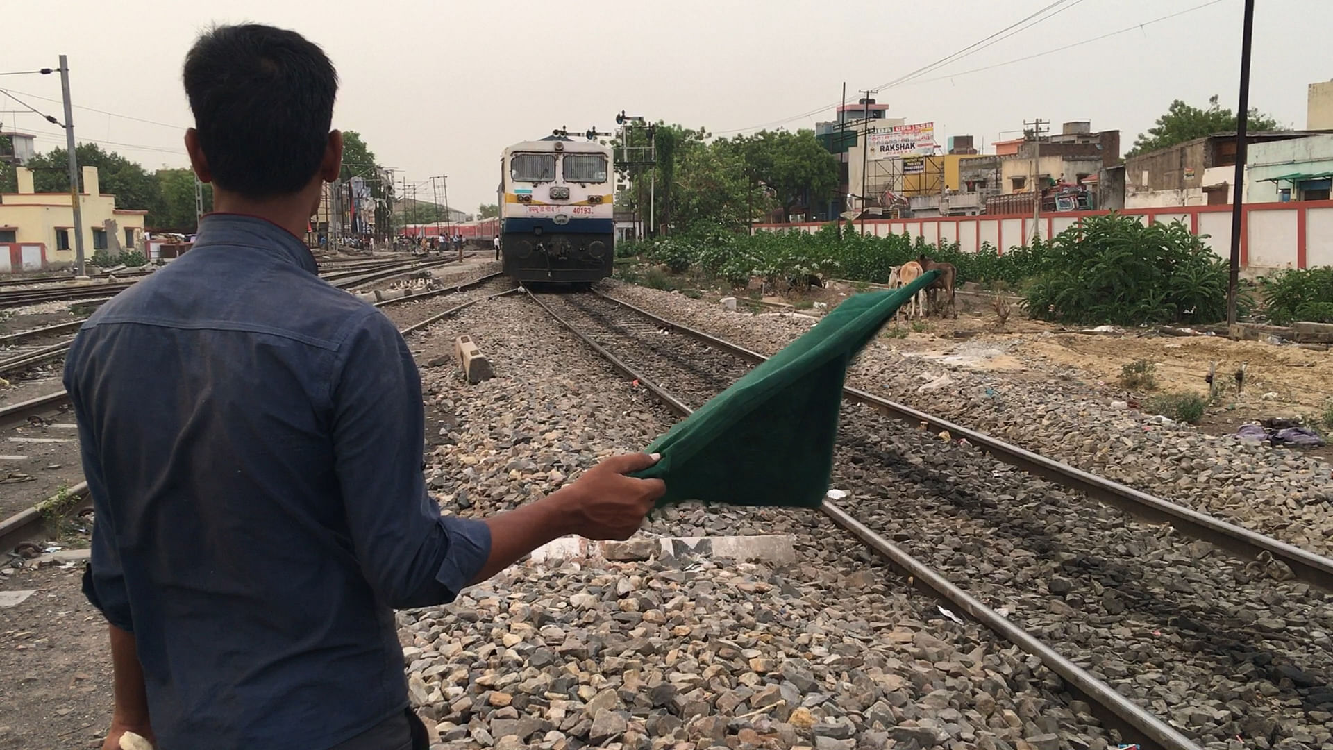 Railway personnel showing the flag to the train at Manduadih railway station.