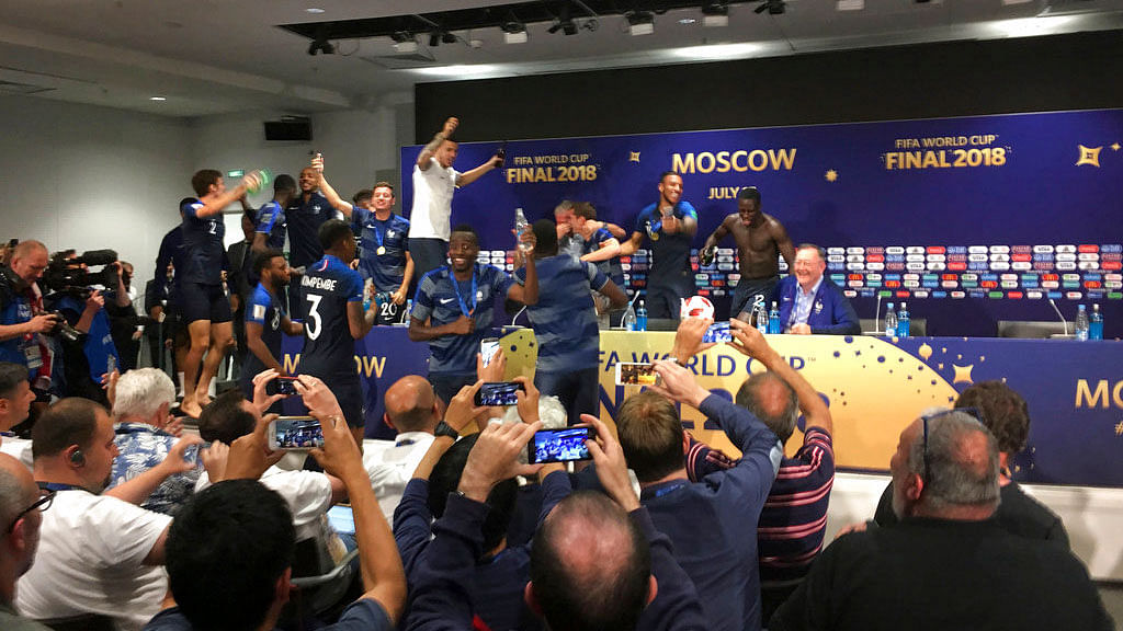 French players celebrate after bursting into a press conference by France head coach Didier Deschamps.