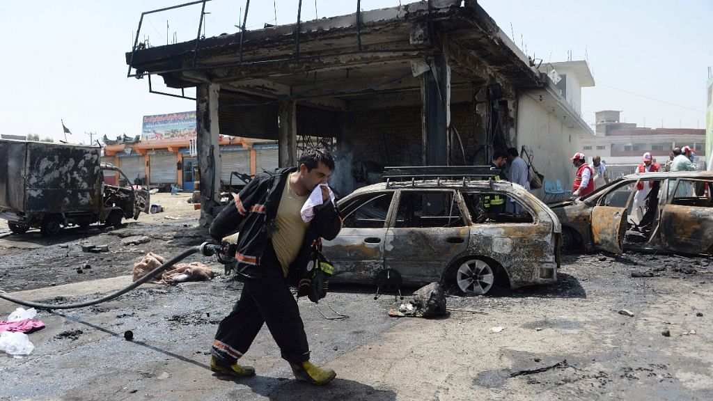 Firefighters work at the site of a deadly suicide attack in Jalalabad, the capital of Nangarhar province, Afghanistan, Tuesday, 10 July, 2018