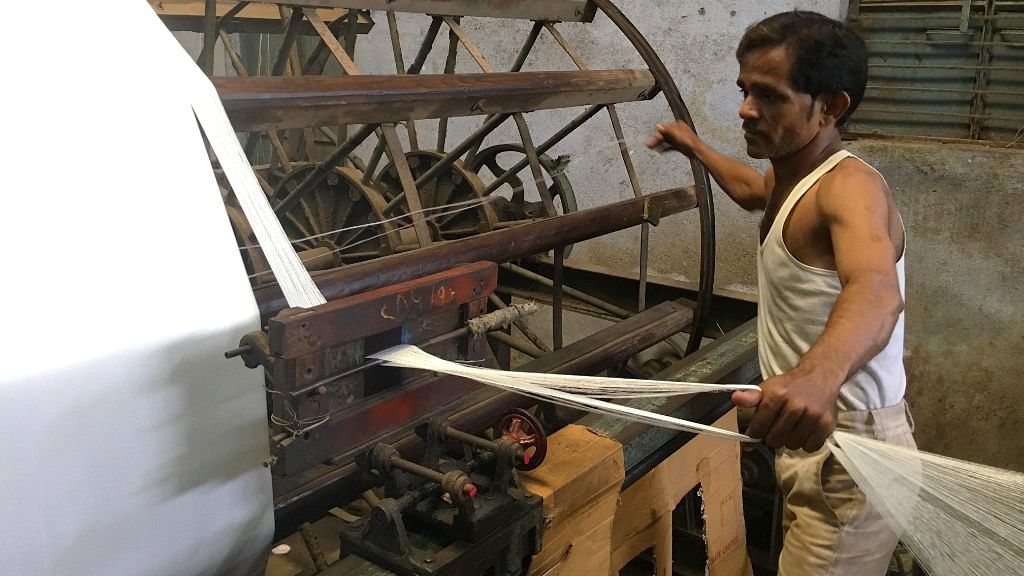 A worker weaves grey cloth at a power loom in Bhiwandi.