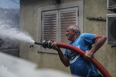 KINETA (GREECE), July 23, 2018 (Xinhua) -- A man tries to put out flames at Kineta near Athens, Greece, July 23, 2018. Western and Eastern Attica were declared in state of emergency by local authorities on Monday as three major wildfires were raging in suburbs and seaside resorts near the Greek capital, forcing hundreds of residents to abandon their homes and seek refuge by the sea, Greek national news agency AMNA reported. (Xinhua/Lefteris Partsalis/IANS)