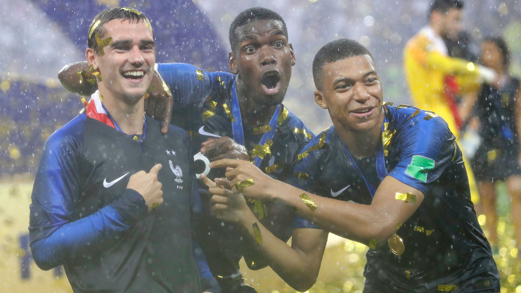 Antoine Griezmann (L) celebrates France’s World Cup win with Paul Pogba (C) and Kylian Mbappe (R).