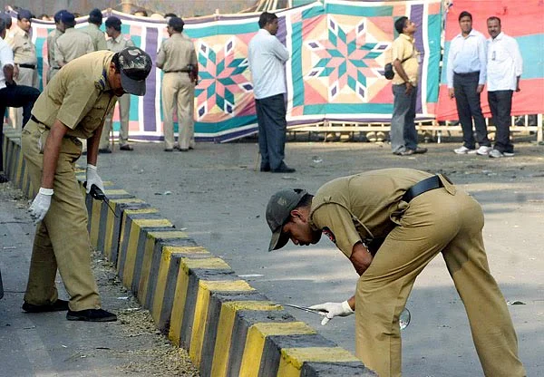Policemen inspecting the scene after the 2010 Chinnaswamy stadium blast. 