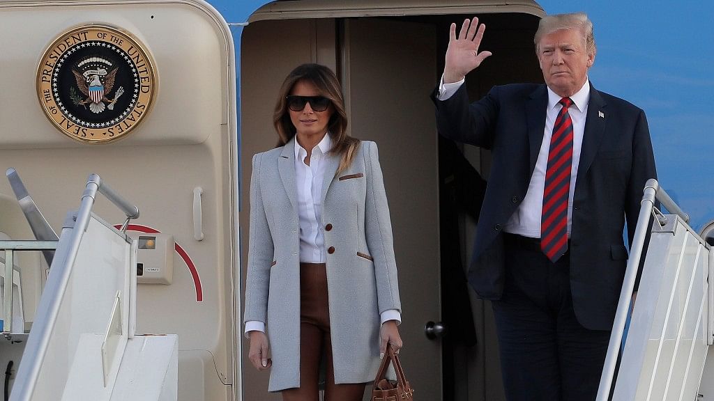 US President Donald Trump waves as he and his wife Melania arrive at the airport in Helsinki, Finland.