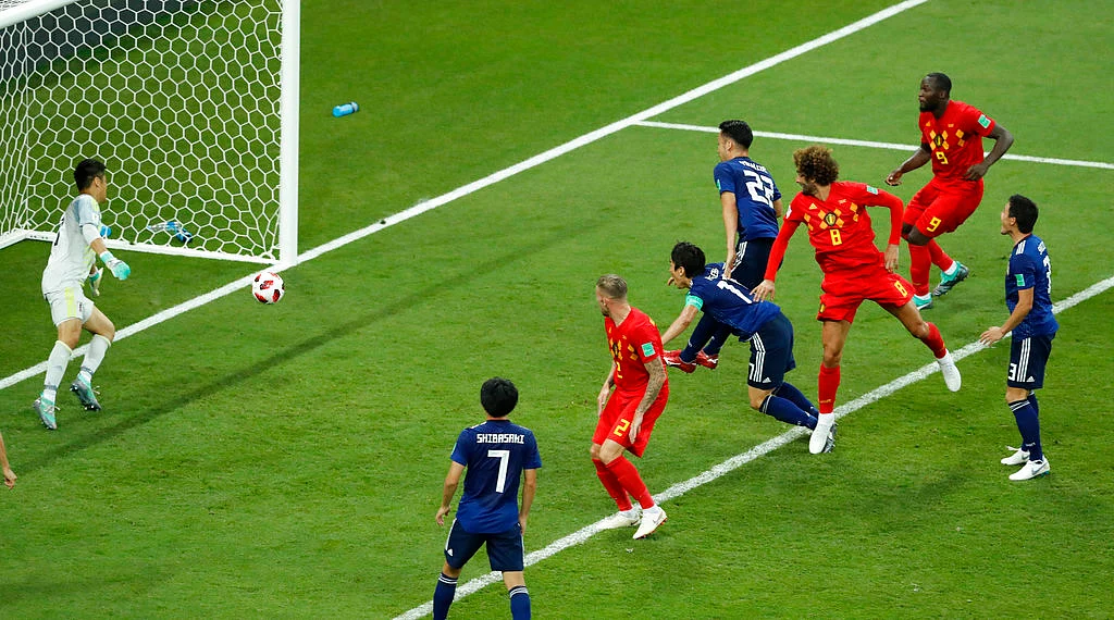 Marouane Fellaini heads the ball past a hapless Eiji Kawashima, the Japanese keeper