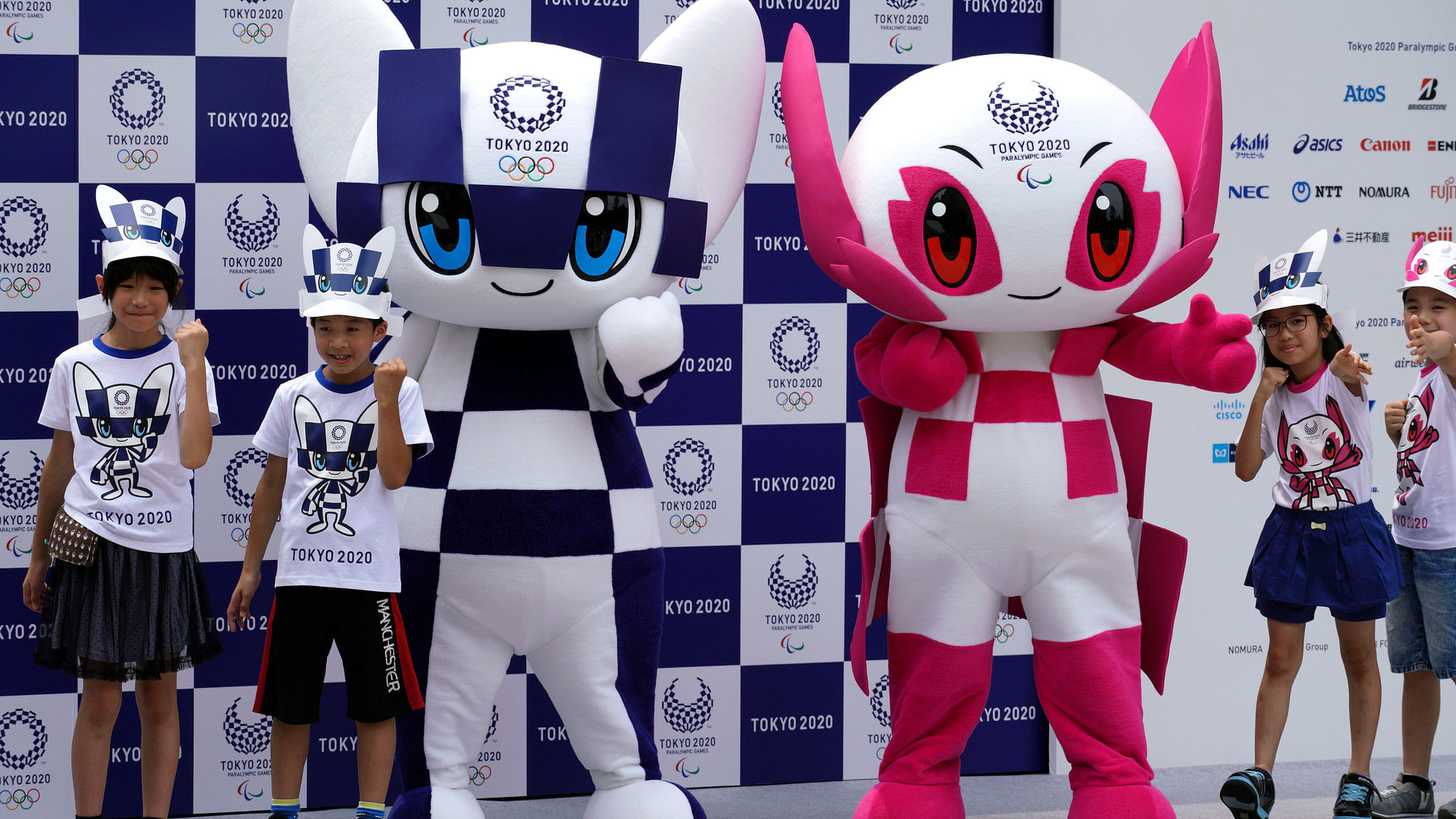 Tokyo 2020 Olympic mascot “Miraitowa”, left, and Paralympic mascot “Someity”, right, pose with children for photographers during the mascot debut event in Tokyo.