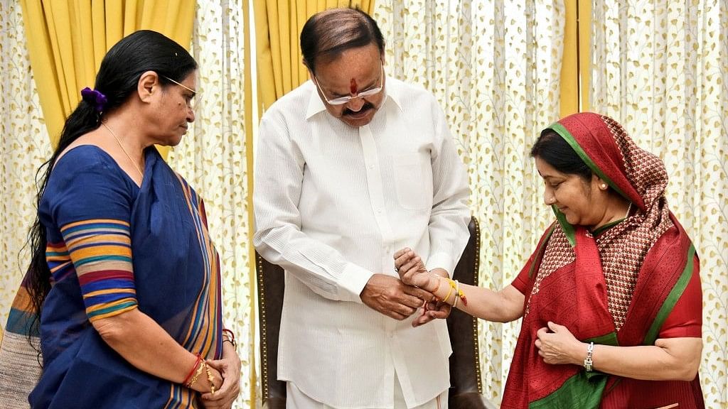 Vekaiah Naidu tying a rakhi to the external minister, Sushma Swaraj.&nbsp;