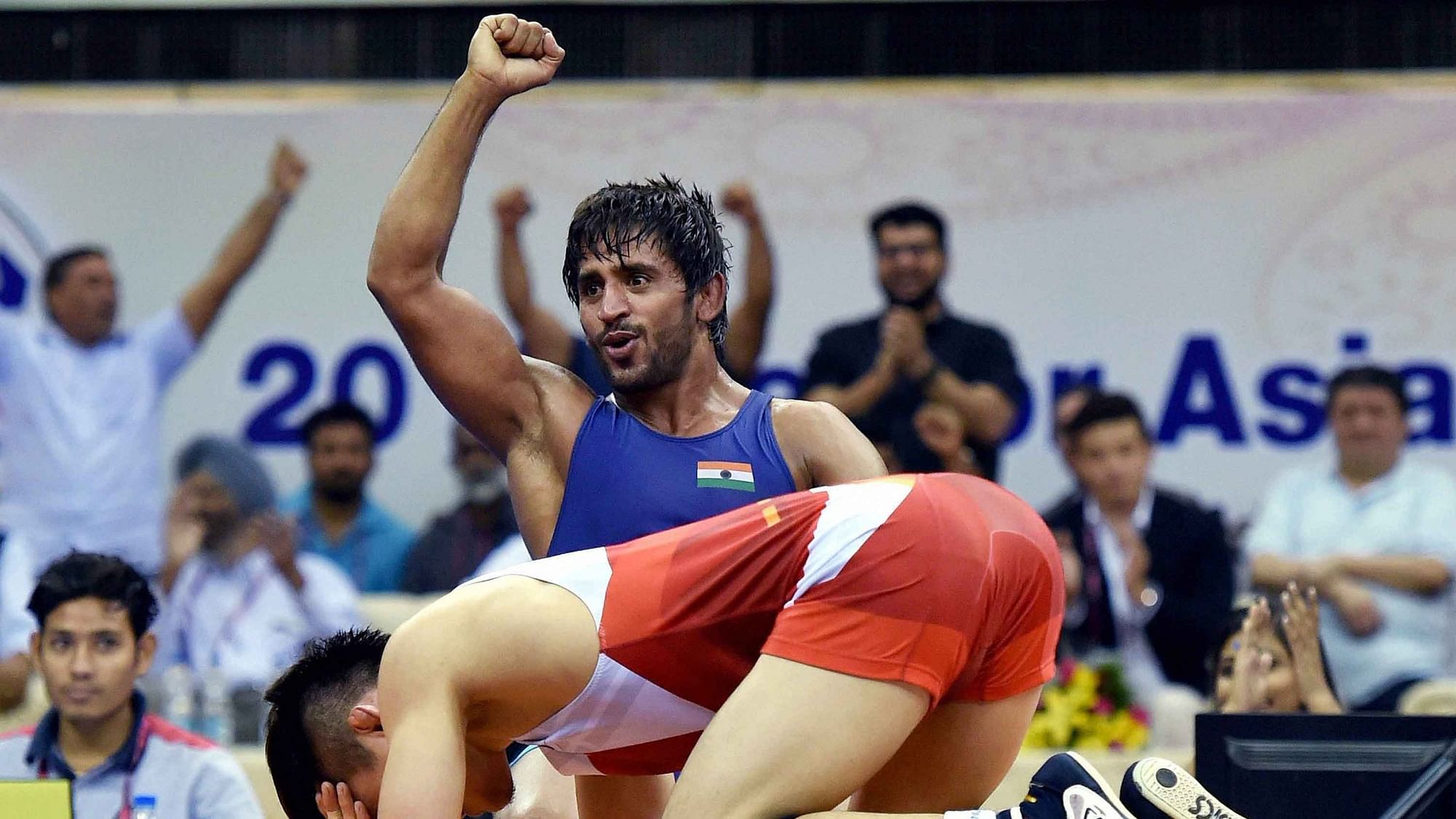 Asian Games 2018: India’s wrestler Bajrang Punia with Uzbekistan’s Khasanov Sirojiddin in the men’s freestyle wrestling (65kg) qualification round at the Asian Games 2018, in Jakarta on Sunday, August 19, 2018.&nbsp;