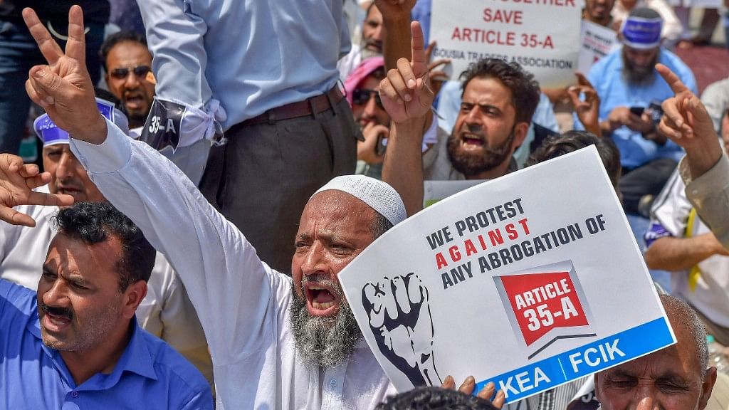 Kashmiri traders hold placards and raise slogans during a sit-in protest against the petitions in the Supreme court challenging the validity of Article 35A, in Srinagar on Sunday, August 05, 2018.