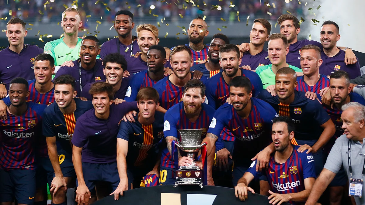 Barcelona players pose with the trophy after winning the Spanish Super Cup soccer match between Sevilla and Barcelona in Tangier, Morocco, Sunday, Aug. 12, 2018. Barcelona won 2-1. 