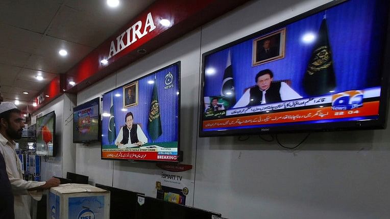 People watch a televised address by Pakistan’s newly elected Prime Minister Imran Khan at an electronic shop in Karachi, Pakistan.