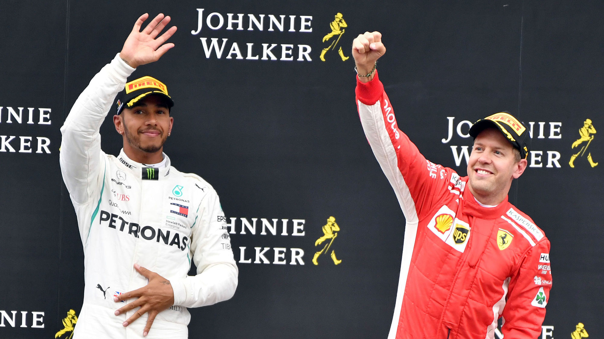 Ferrari driver Sebastian Vettel of Germany, right, jubilates on the podium after winning the Belgian Formula One Grand Prix.