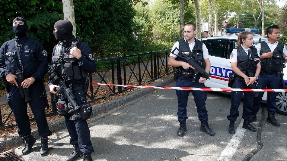 French hooded police officers guard the area with other police officers after a knife attack  in Trappes, west of Paris.