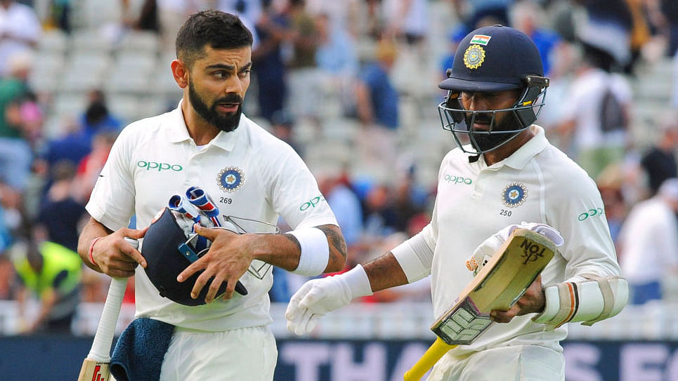 Virat Kohli and Dinesh Karthik walk off the ground at the end of Day 3 of the first Test against England.