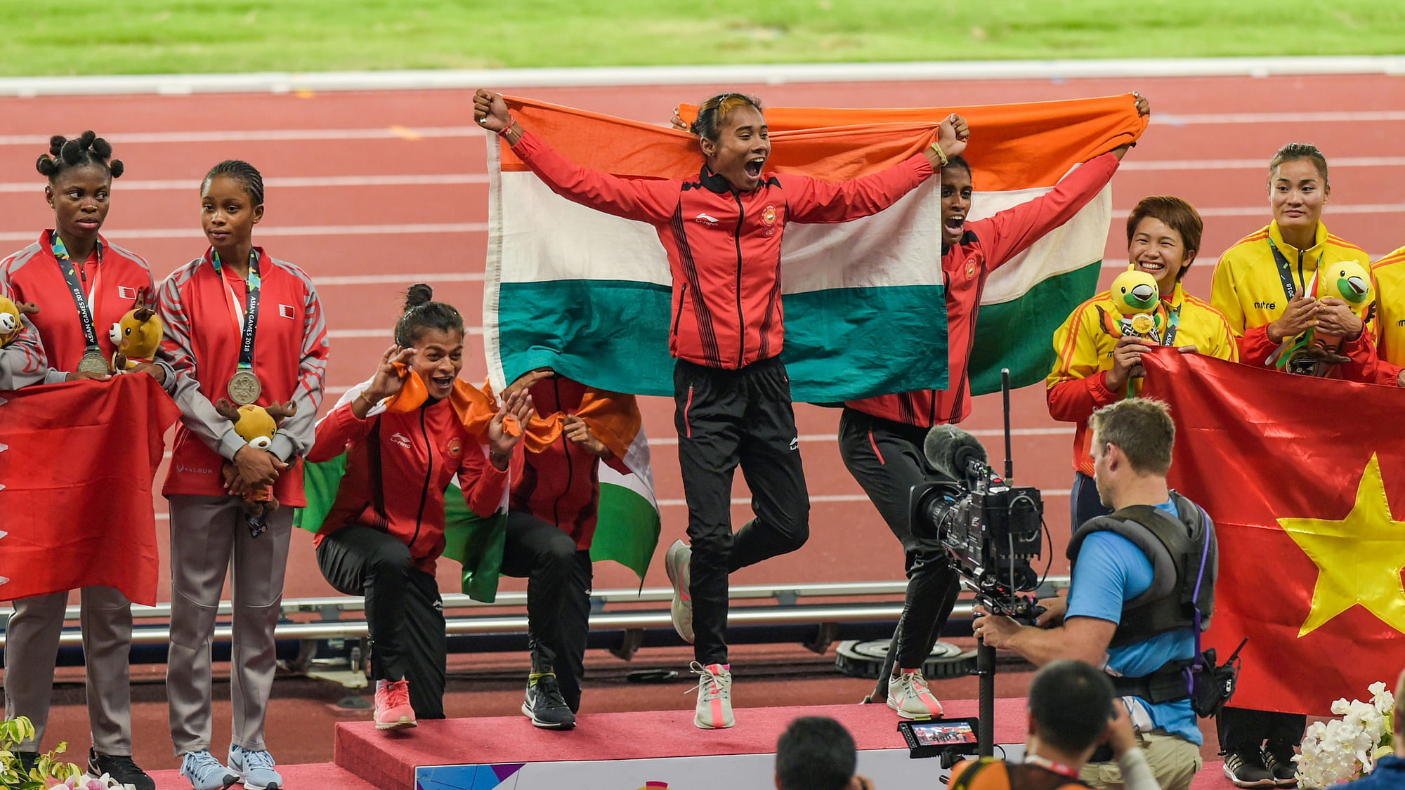 Indian women’s 4x400m relay team celebrate on the podium with their gold medals.