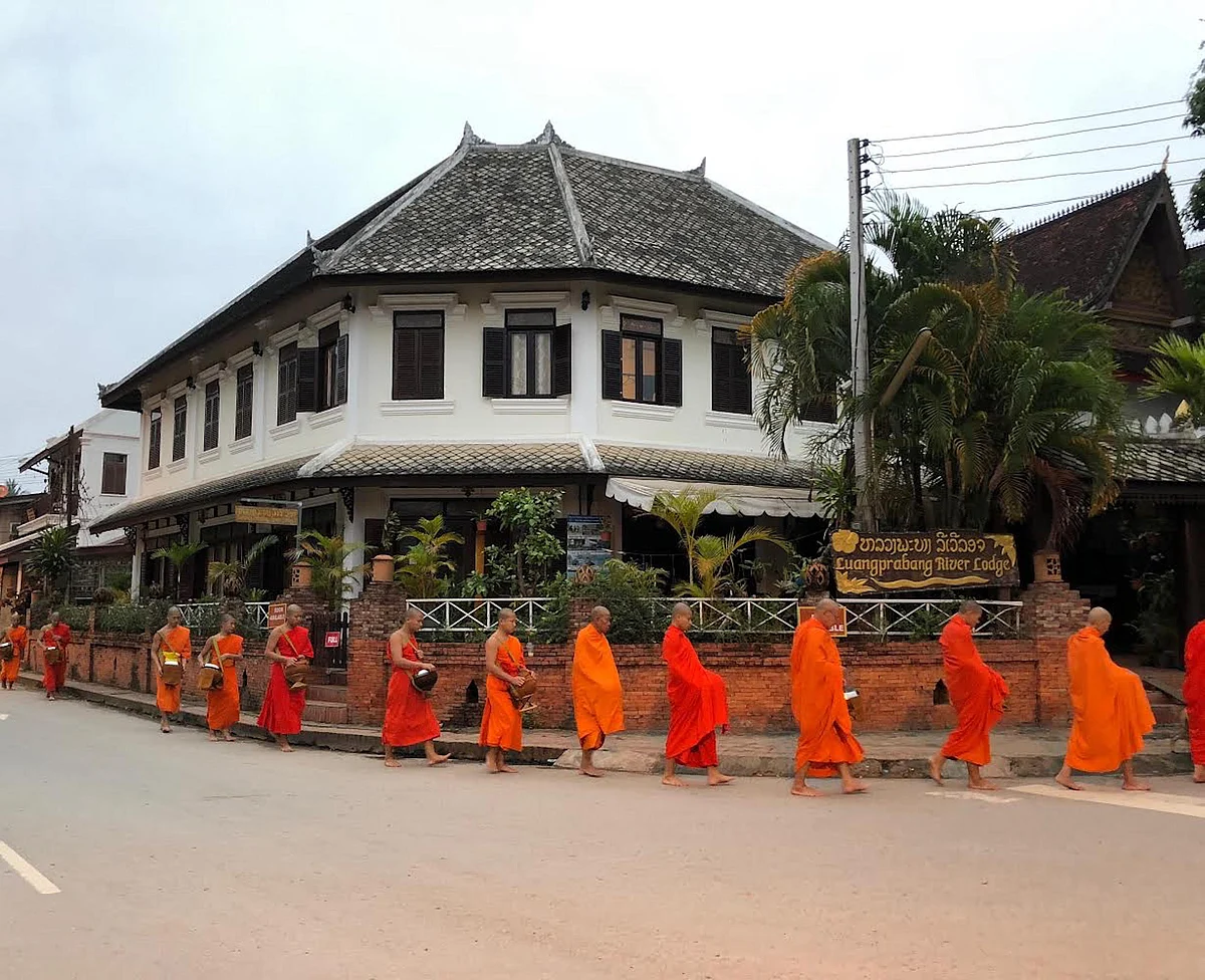 Locals shower the monks with rice, fruits and traditional sweets.