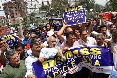 Srinagar: Members of Kashmir Chamber Of Commerce and Industry stage a demonstration against petitions challenging Article 35A in the Supreme Court; in Srinagar on Aug 1, 2018. Article 35A, promulgated by the President in 1954, gives powers to the Jammu and Kashmir legislature to define the permanent residents of the state and also their privileges. However, its constitutional validity has been challenged in the apex court where the case will come up for next hearing on August 6. (Photo: IANS)