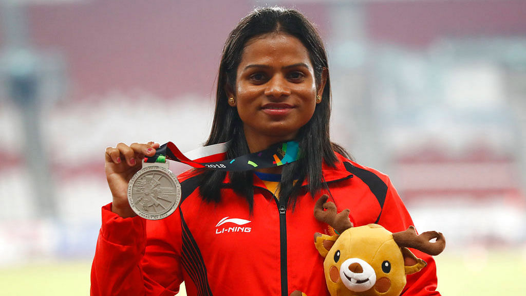 Dutee Chand stands with her 200m silver medal on the podium.