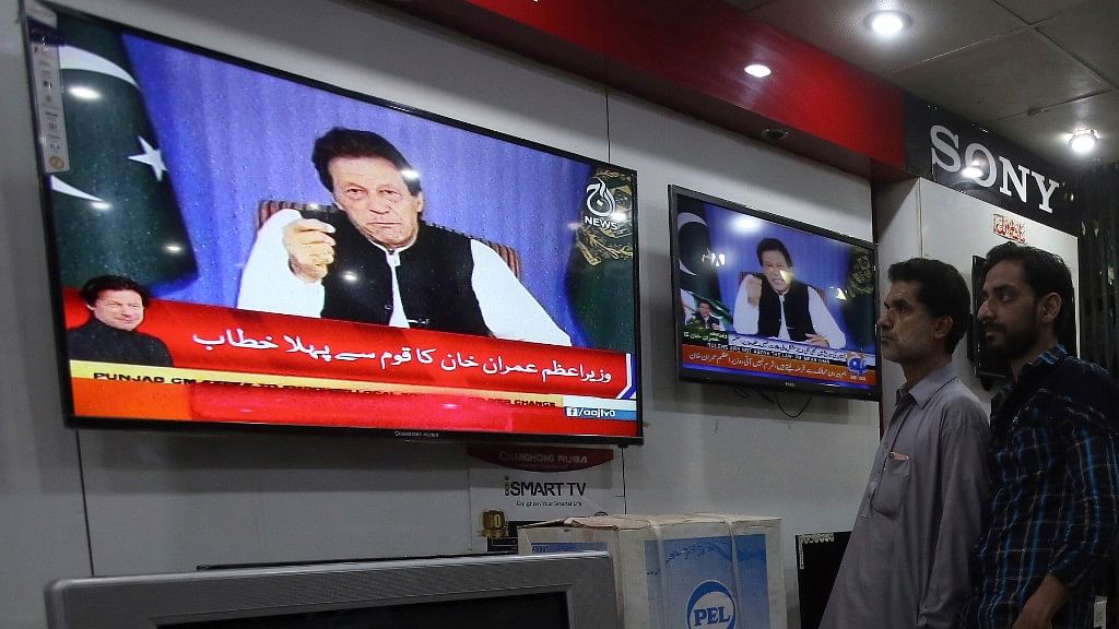 People watch a televised address of Pakistan’s newly elected Prime Minister Imran Khan at an electronic shop in Karachi, Pakistan, on Sunday, 19 August, 2018.