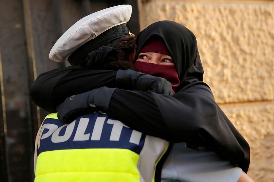 Danish police hugs a woman wering a niqab despite the recent ban.