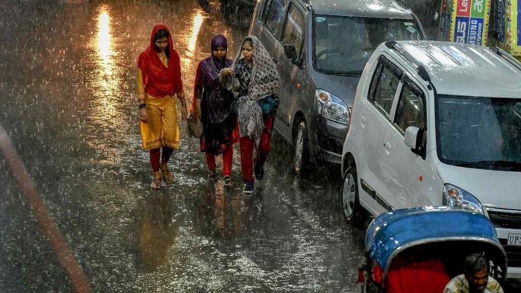 Pedestrians try to make their way across a street during heavy rain in Uttar Pradesh. Image used for representational purpose.