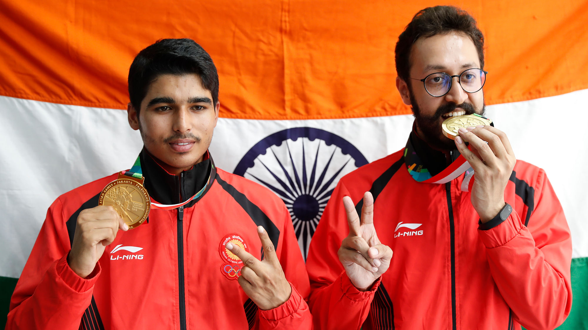 Bonze medalist India’s Abhishek Verma, right, and gold medalist India’s Saurabh Chaudhary, poses for photographer with India national flag after the 10m air pistol men’s final shooting event during the 18th Asian Games.