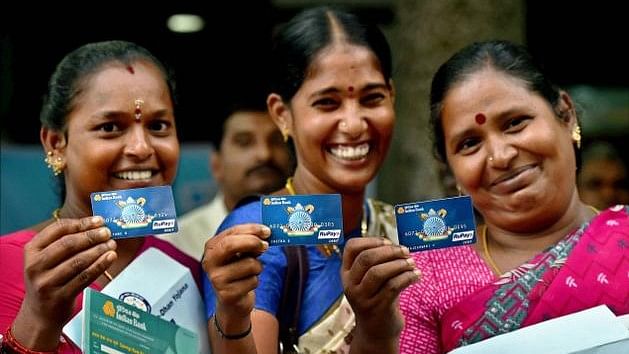 Women holding their Jan Dhan account cards.&nbsp;