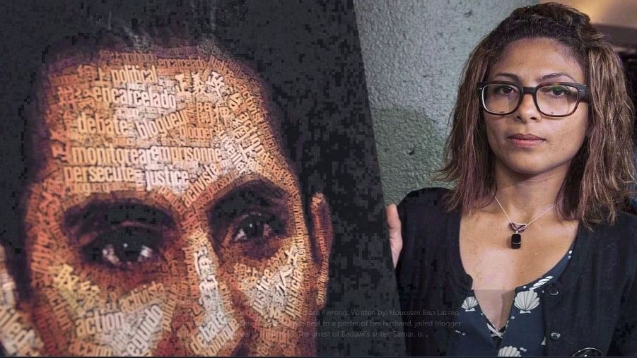 Ensaf Haidar stands next to a poster of her husband, jailed blogger Raif Badawi, in Montreal in June 2015. The arrest of Badawi’s sister, Samar, is at the centre of a bitter spat between Canada and Saudi Arabia.