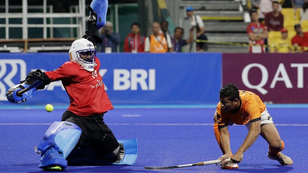 India’s goalkeeper Sreejesh Parattu Raveendran tries to block a shot from Malaysia’s Muhammad Firhan during their men’s hockey semi-final match.